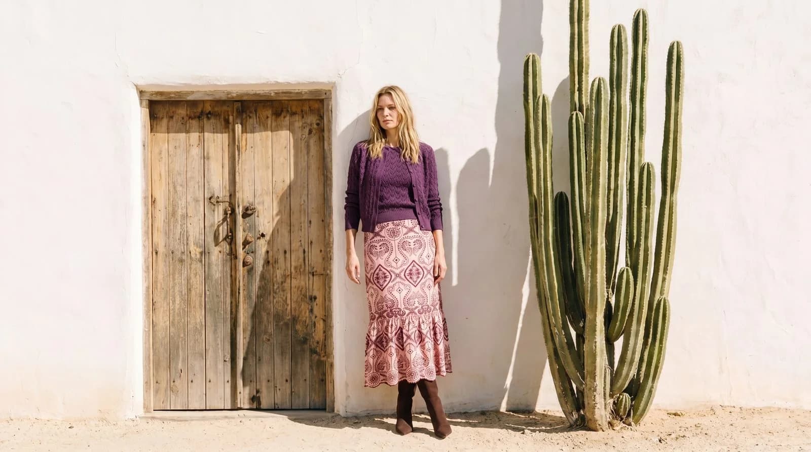 Cartolina: A purple skirt beside a cactus-lined wall.