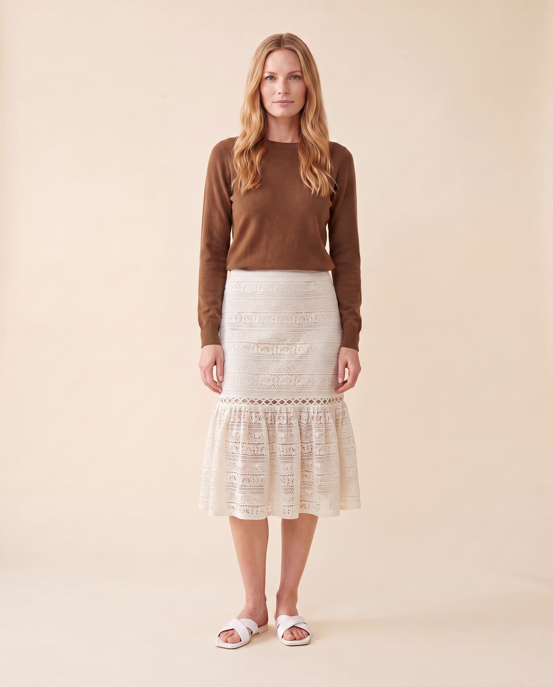 An AI model wears the Cartolina Marlo skirt in ecru lace with the Perry tie-neck top, standing full length on a cream studio backdrop.