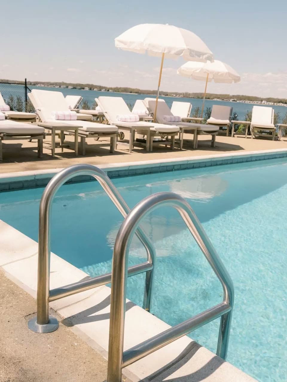 The edge of the Pridwin pool with umbrellas beyond, water moving against the coping.