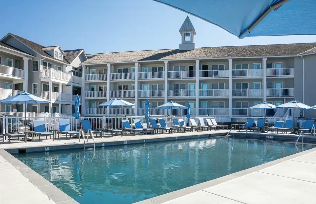 The pool at Sandpiper Beach Club, blue umbrellas turning above the moving water.