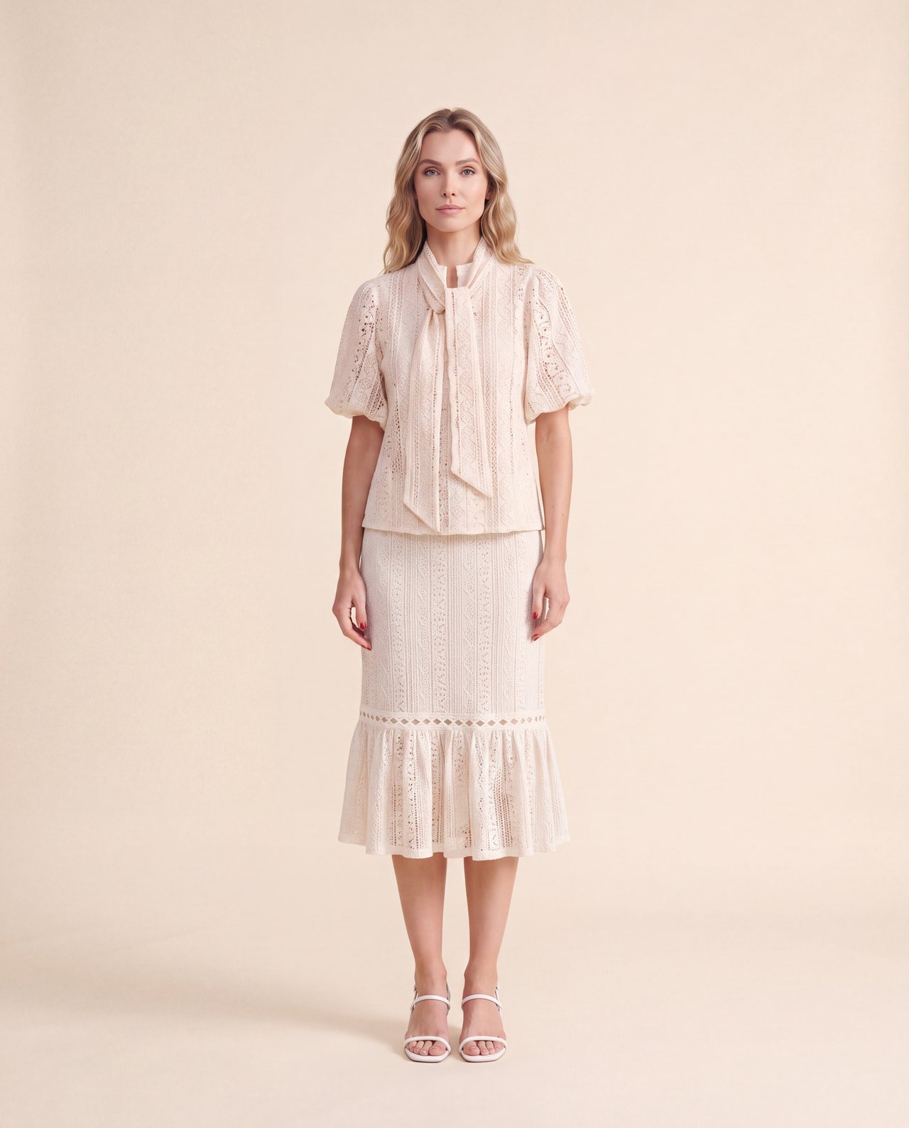 An AI model wears the Cartolina Marlo skirt in ecru lace with the Perry tie-neck top, standing full length on a cream studio backdrop.