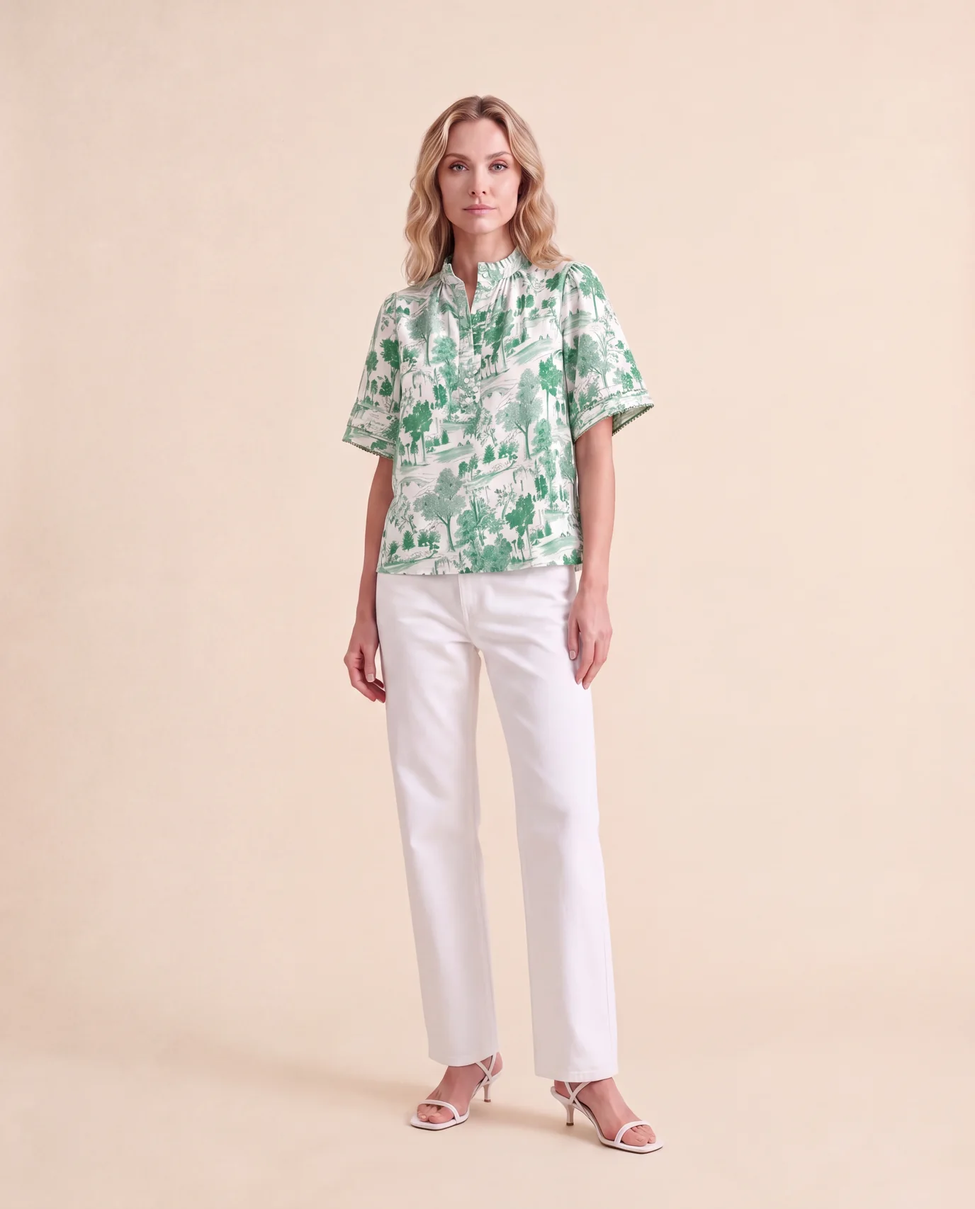 A model in Cartolina's Emery top in golfers toile and white jeans, on a sand-colored backdrop.