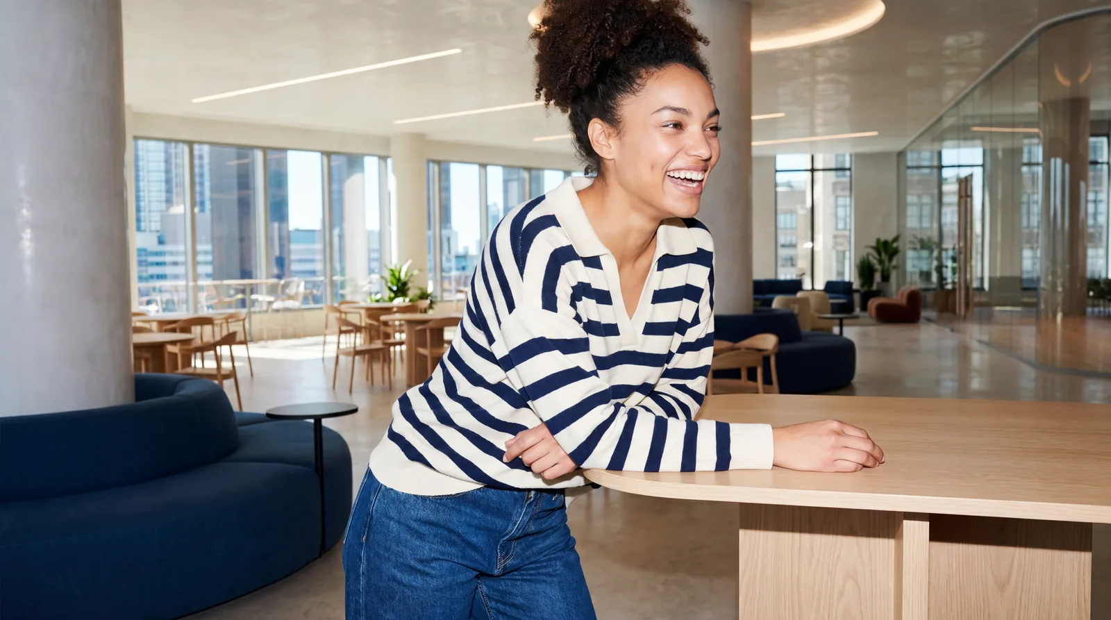 A person stands at a counter inside a bright office.