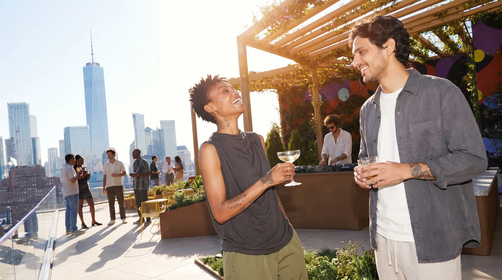 Two people talk on a landscaped terrace at sunset.